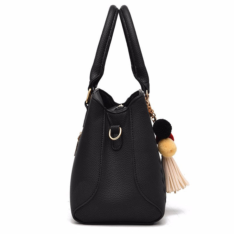 Embossed handbag with pompom charm