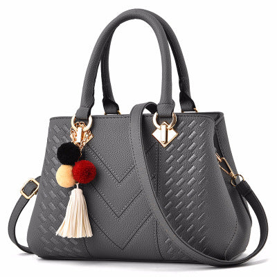 Embossed handbag with pompom charm