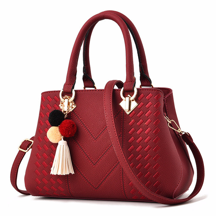 Embossed handbag with pompom charm
