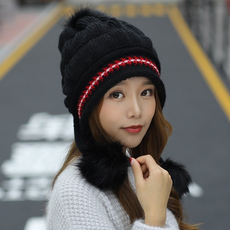 Woman in an ear flap beanie with pompom
