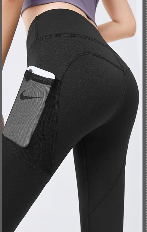 Woman wearing black high-waist leggings with phone pocket