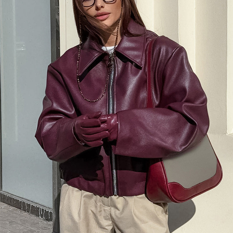 Woman in a cropped burgundy leather jacket